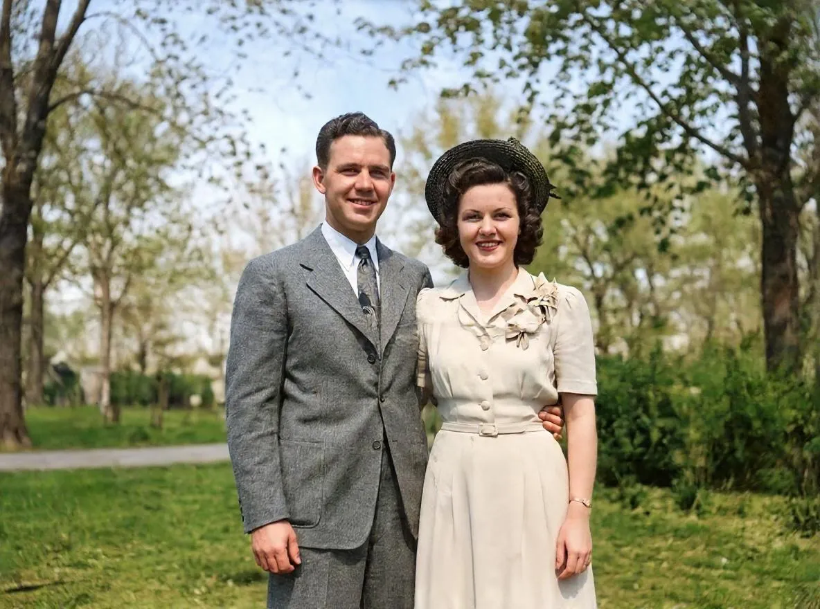 La misma pareja restaurada y coloreada con Retrocap: el hombre con traje gris y la mujer con vestido crema y sombrero de paja